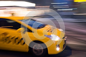 Taxi car moving fast in the night city in motion blur