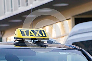 Taxi car on the street at day time,taxi sign on the cab roof while parking on the road waiting for passaenger vintage film photo