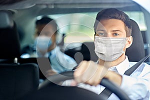 Taxi driver in face protective mask driving car