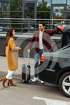 Taxi driver helping passenger with luggage