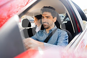 Taxi driver with passenger at back seat.