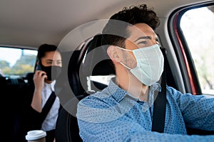 Taxi driver with passenger at back seat.