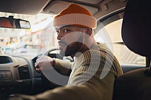 Taxi, ride and man driving in a car as city transport or vehicle travel to a destination in town and looking for parking