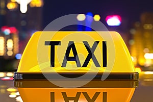 Taxi service concept, taxi sign on the night city background. 3D rendering