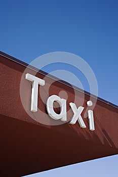 Taxi Sign On a Brown Wall