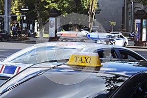 Taxi sign by car and traffic police