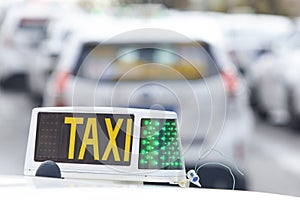Taxi sign with out of focus vehicles. Urban transportation