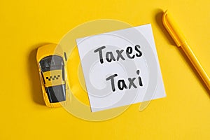Taxi tax concept as an inscription on a sticker next to a toy car on a yellow background