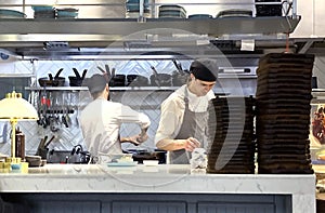 Tbilisi, Georgia - May 01 2022: two chefs cooking in an open kitchen