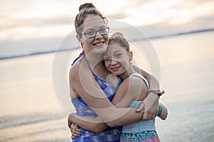 Tchildren sister hugging at the sunset beach