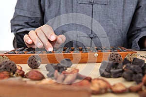 TCM doctors use traditional Chinese abacus to calculate the amount of medicine on prescription photo