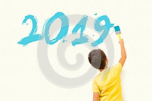 Te little boy kid writing new year 2019 with painting brush