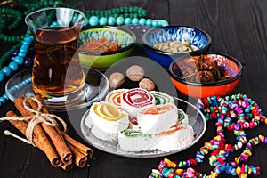 Tea in Azerbaijani traditional armudu and pile of sweets on table
