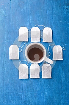 Tea bag and cup on the blue background.