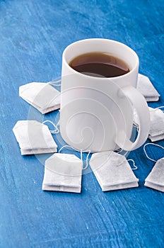 Tea bag and cup on the blue background.