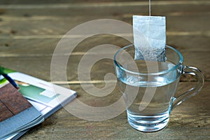 Tea bag hanging over a hot glass of water. Preparation of making tea.