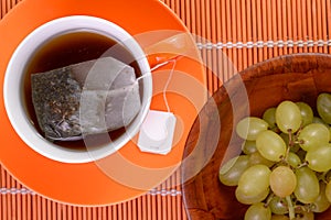 Tea bag infusing in cup Grapes Healthy snack