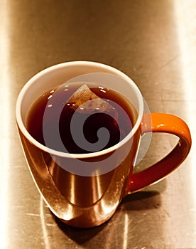 Tea Bag Steeping In Orange Ceramic Cup