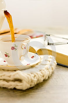 Tea being poured into china teacup vertical