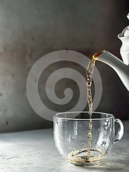 Tea being poured into glass tea cup with steam