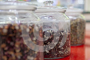 Tea blends in glass jars on the counter of the cafe. Bright colors of tea