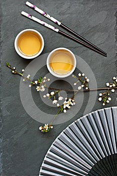 Tea bowls  and  cherry  flowers on  dark  background