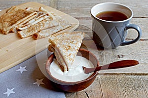 Tea break with Russian style pancakes during Maslenitsa Old wooden background