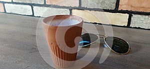 Tea in clay glass on table with goggles