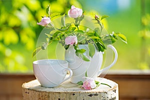 Tea crockery and wild rose flowers