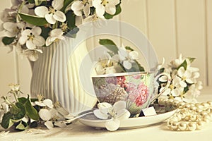 Tea cup with apple blossoms on table