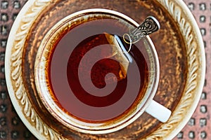 Tea in a cup with a bag and spoon on a saucer