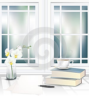 Tea cup on books pile beside the window on the table