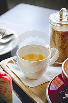 Tea cup and coffee and cake on wood table in restaurant