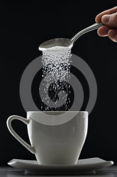 Tea cup or coffee and pouring sugar spoon