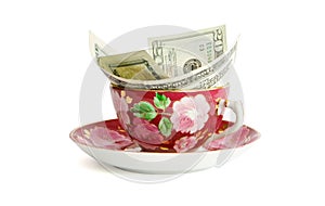 Tea cup with dollar bills isolated