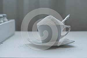 Tea cup full of white sugar