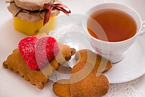 Tea cup with heart shaped biscuits. Sugar red biscuits.