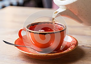 Tea cup with hot tea pot
