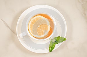 tea cup with a lemon and mint/tea cup with a lemon and mint on a white marble background, top view