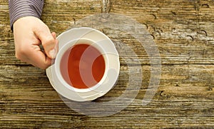 Tea cup male hands holding cafe table wooden top view