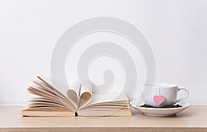 Tea cup with red heart on book shelf. Valentines day