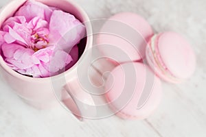 Tea cup with rose and macaroons, selective focus