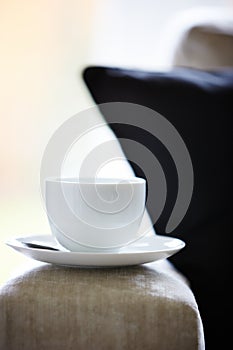 Tea cup and saucer on sofa armrest