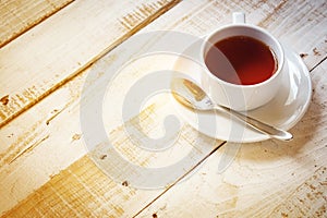 Tea cup and spoon on saucer with table of morning sunlight for copy space