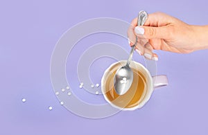 Tea cup with sugar substitute on color background