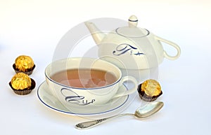 Tea cup, teapot and chocolates