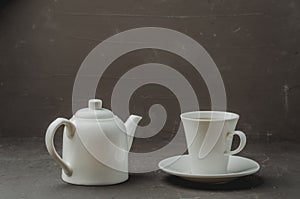 Tea cup and teapot on on dark stone table. Selective focus