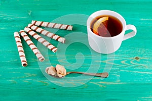 Tea in a cup and wafer tubules in a plate