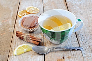 Tea, cupcake, cinnamon sticks and lemon slice