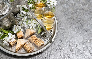 Tea cups and pot. Oriental silver tableware. Flowers decoration